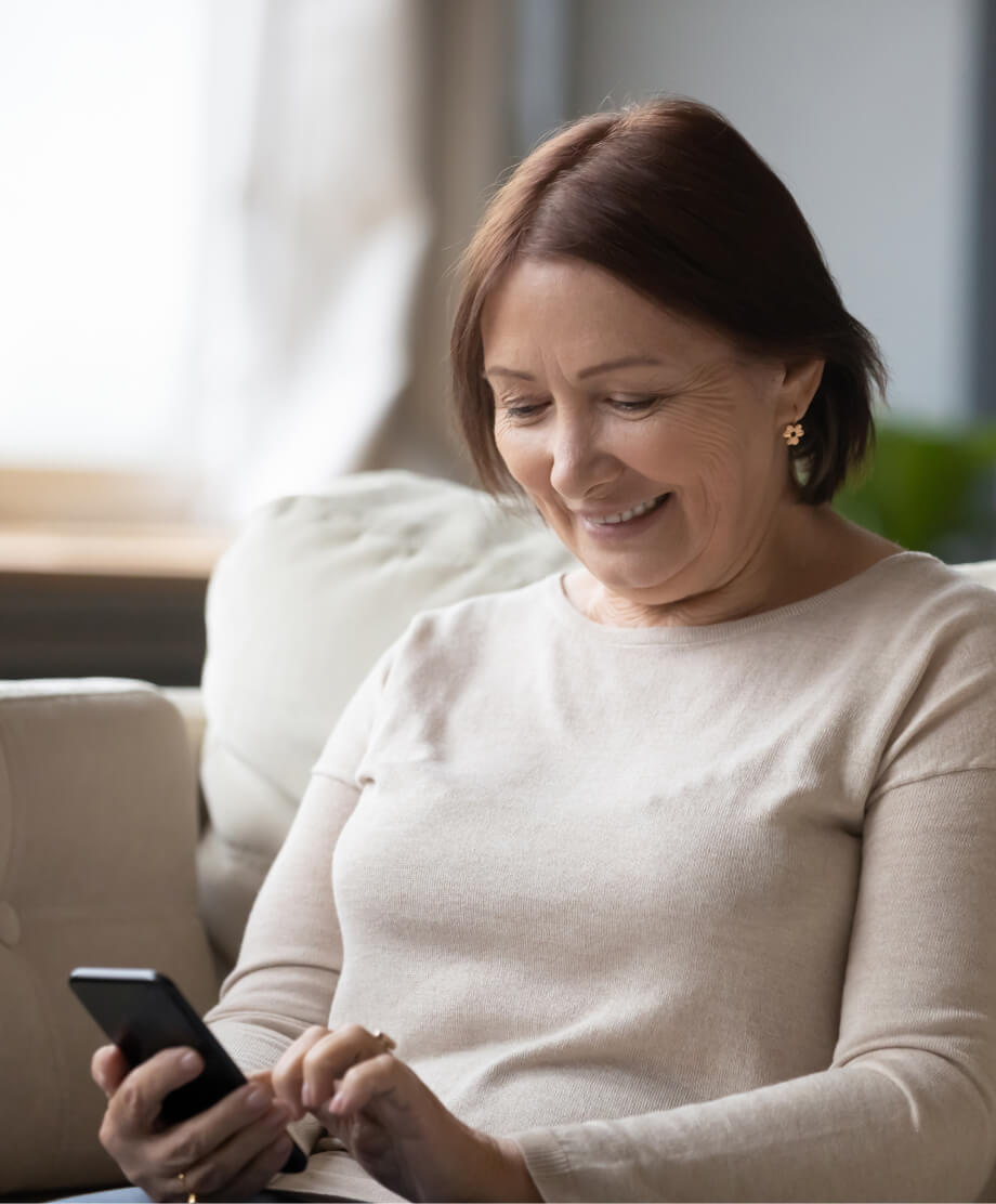 woman-phone-home-1 Smiling woman looking at her smartphone.
