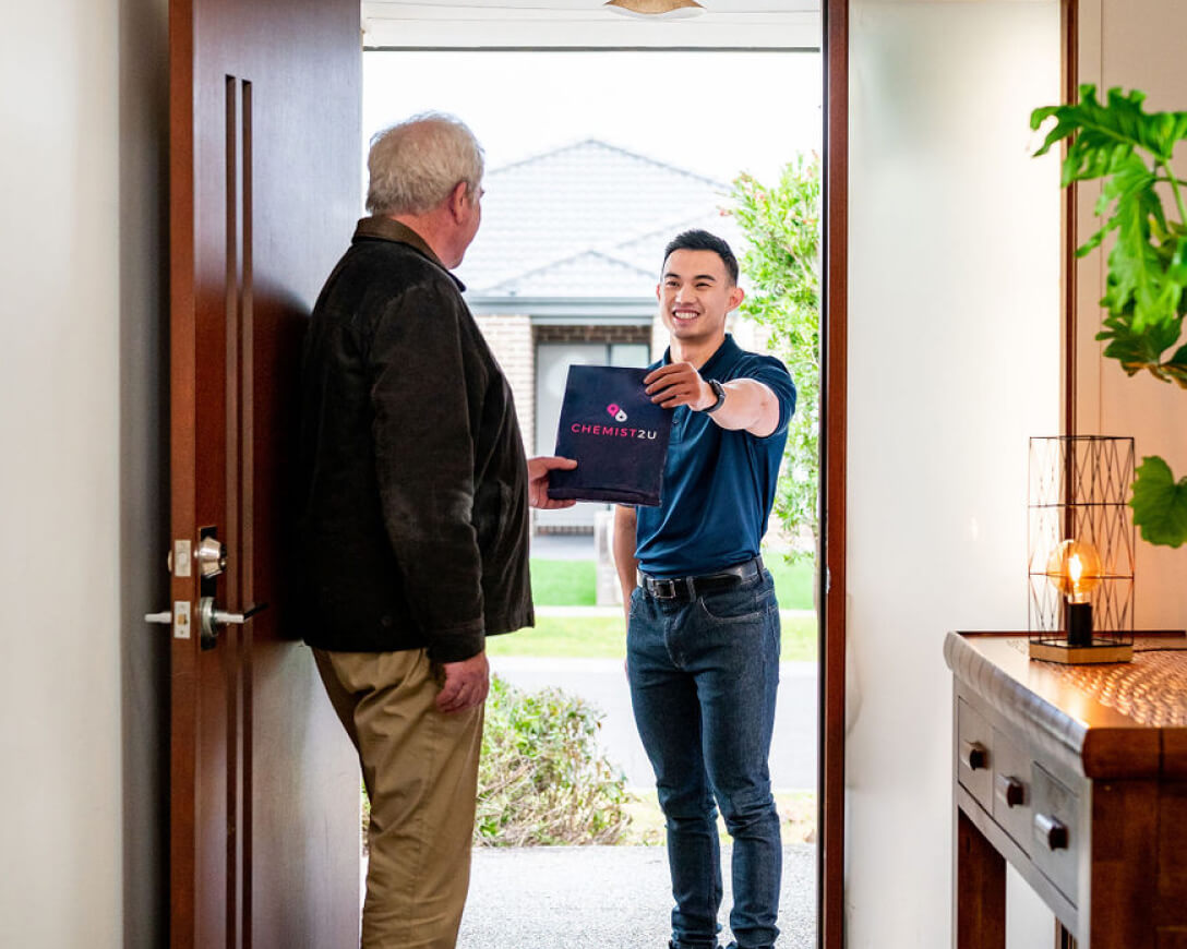 customers Courier delivering medication to customer's home, standing at the doorstep with a package