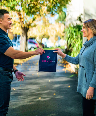 A courier delivering a Chemist2U-branded bag containing medications to a customer.