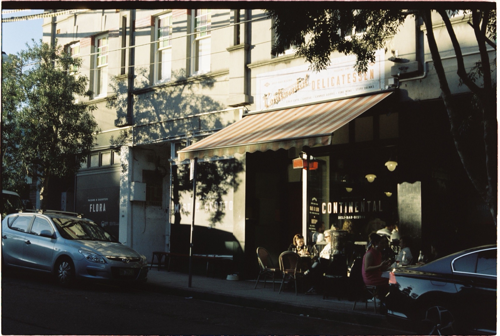 Continental Deli bar and bistro on a Surry Hills side street with outdoor diners in afternoon sun